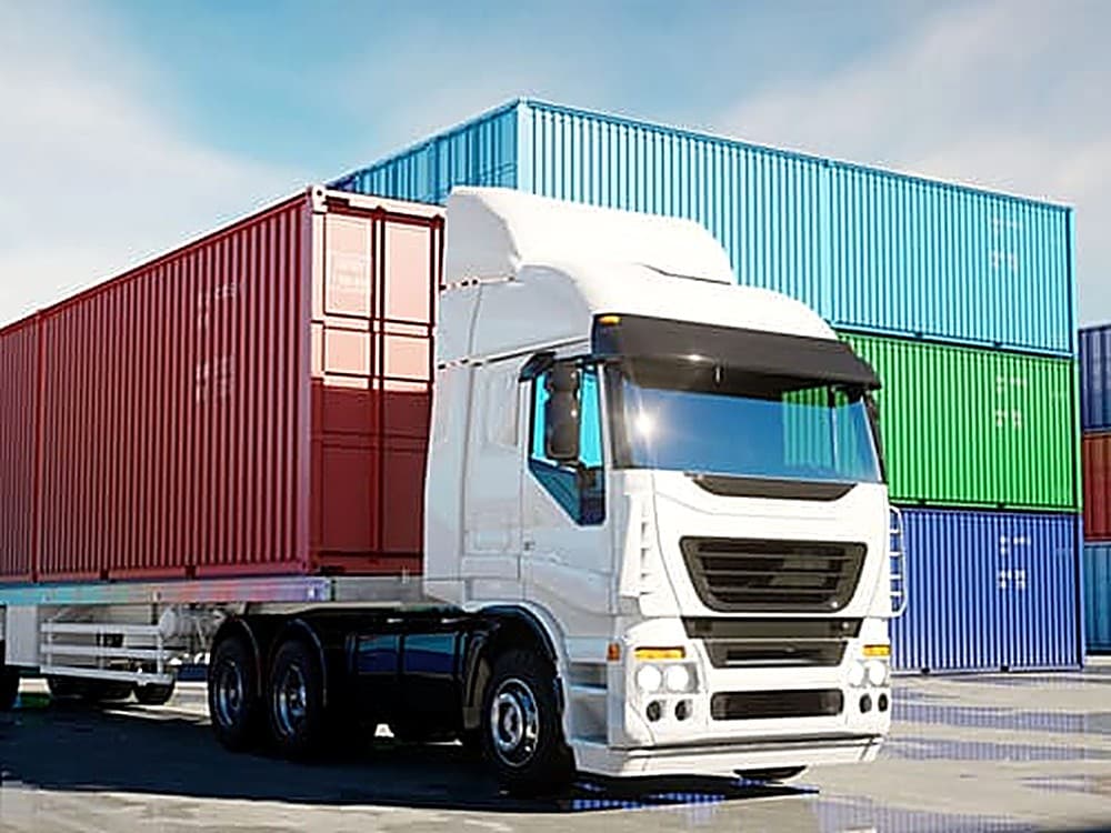Truck hauling a shipping container at a container yard